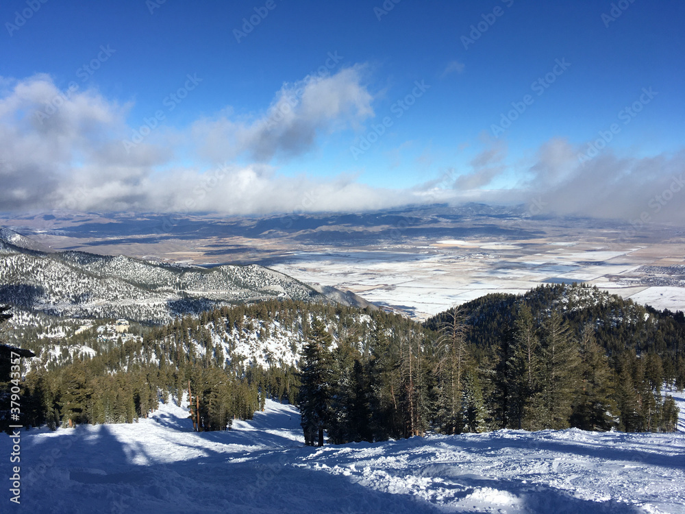 Landscape view of Carson valley and the slopes of a ski resort in tahoe on a sunny winter day with clouds
