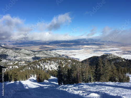 Landscape view of Carson valley and the slopes of a ski resort in tahoe on a sunny winter day with clouds