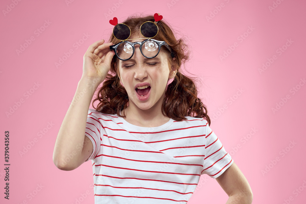 Cheerful girl with pigtails sunglasses striped t-shirt lifestyle pink background