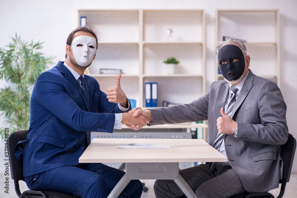 Two businessmen wearing masks during negotiations Two businessmen wearing masks during negotiations