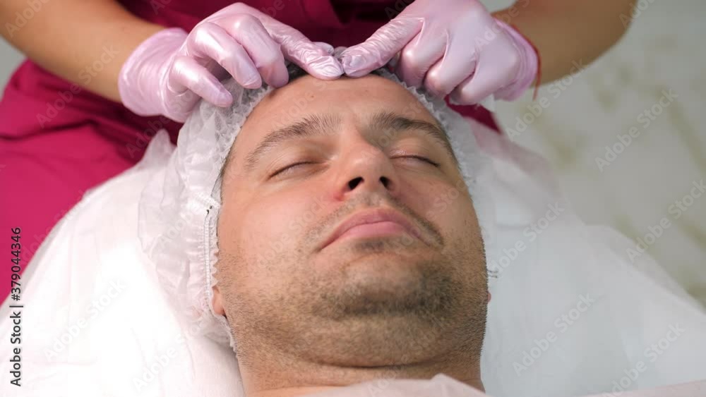 Cosmetician applying peeling to the face of young handsome man Cosmetician applying peeling to the face of young handsome man