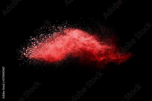 Red powder explosion on black background. Paint Holi.