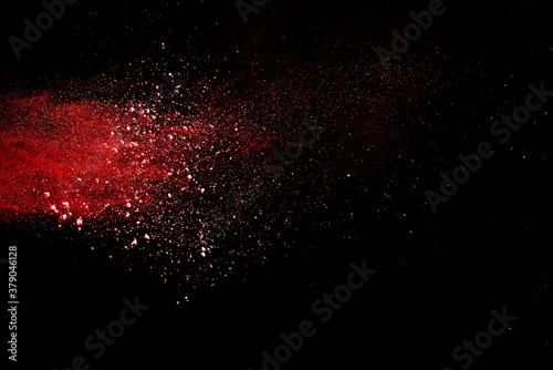 Red powder explosion on black background. Paint Holi.