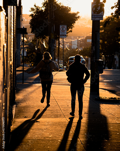 people walking on the street at sunset