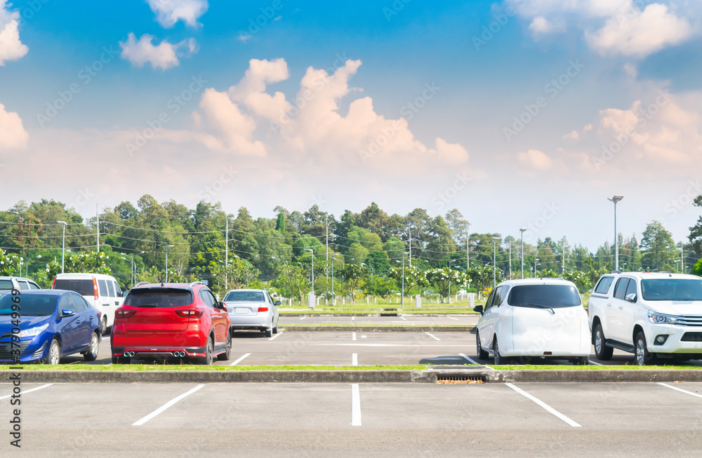 Car parking lot with car parked, cloud and blue sky background. Outdoor parking lot with fresh ozone and green environment of travel transportation technology