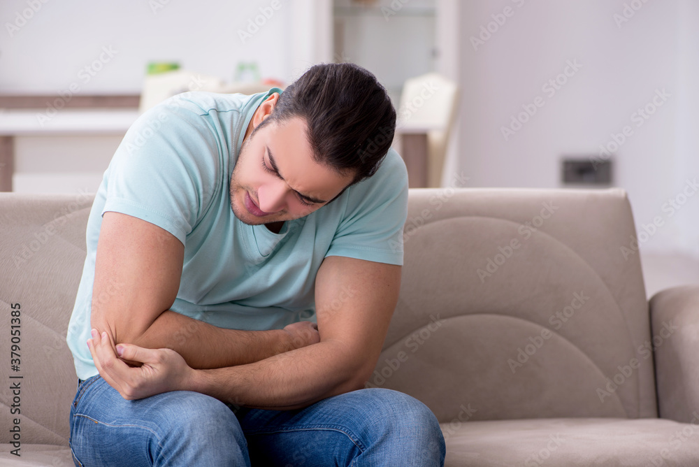 Injured young man suffering at home Injured young man suffering at home