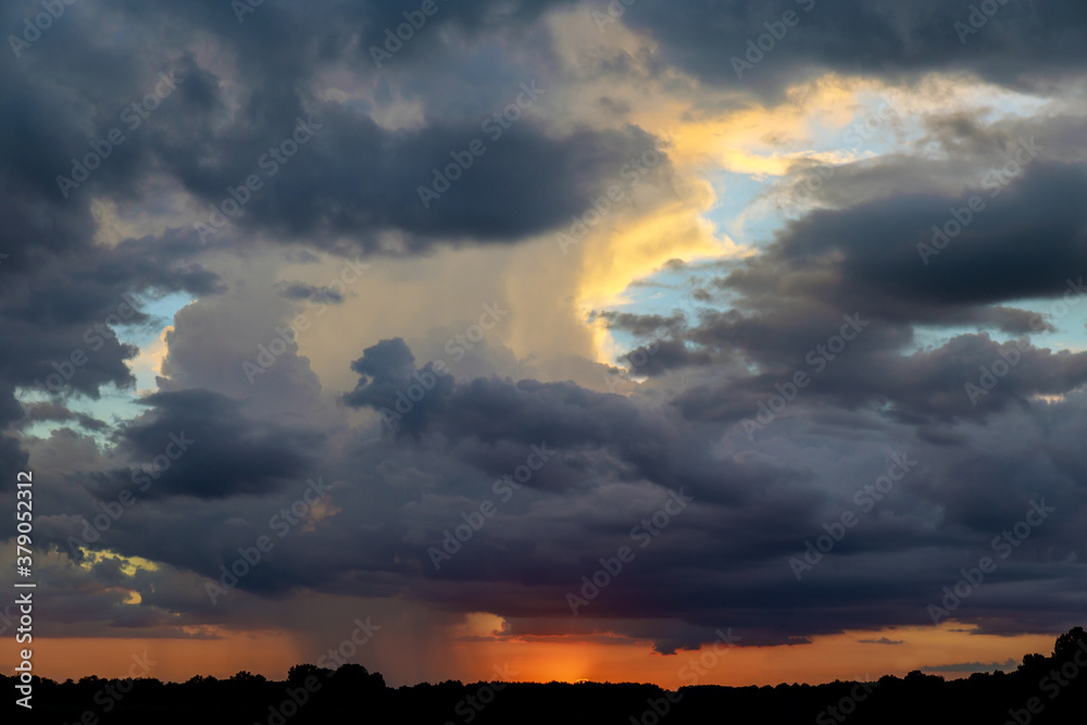 Sunset with dark clouds, rain, tornado or hurricane.