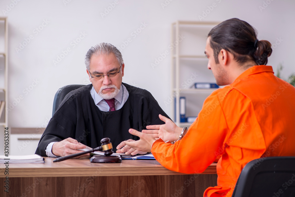 Old male judge meeting with young captive in courthouse Old male judge meeting with young captive in courthouse