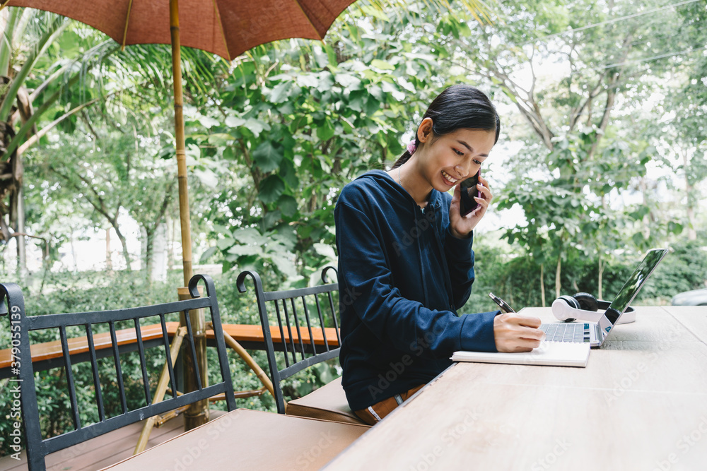 Attractive Asian Thai woman happy working and studying on her laptop outside of coffee shop, business freelance portrait. Attractive Asian Thai woman happy working and studying on her laptop outside of coffee shop, business freelance portrait.