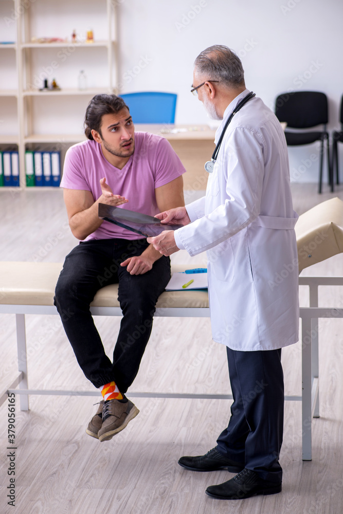 Fototapeta premium Old doctor radiologist examining young male patient