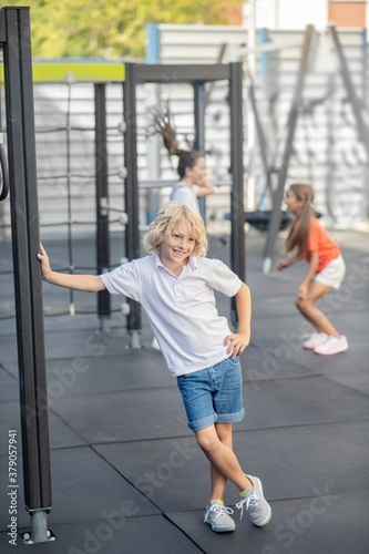 Blonde boy in white tshirt standing and smiling