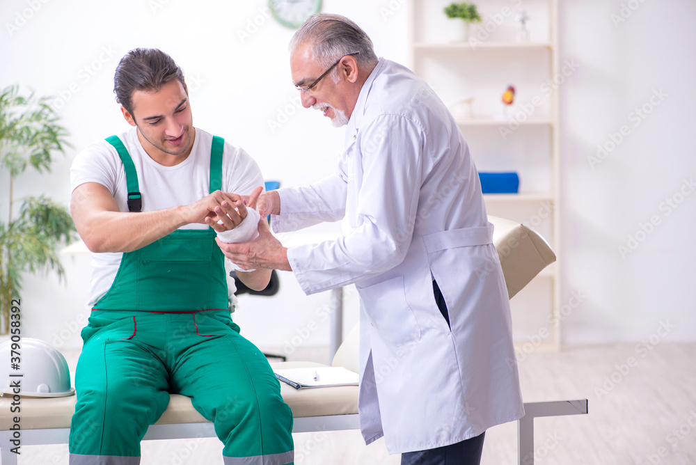 Young male contractor visiting old doctor Young male contractor visiting old doctor