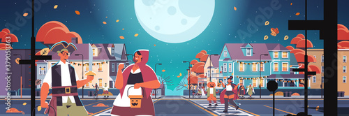 people in costumes walking in town trick or treat happy halloween celebration concept greeting card horizontal vector illustration