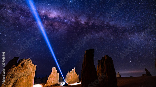 Man laying in the Pinnacles Western Australia with head torch watching the Milky Way