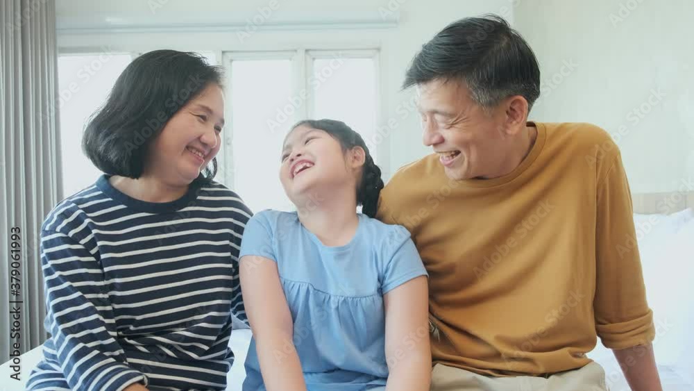 Happiness asian Grandmother and grandfather playing on bed together laugh smile with their granddaughter. Happiness asian Grandmother and grandfather playing on bed together laugh smile with their granddaughter.