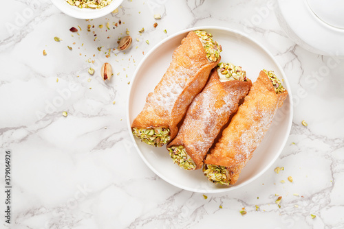 Sweet homemade cannoli stuffed with ricotta cheese and pistachio. Sicilian dessert. Italian pastry.	