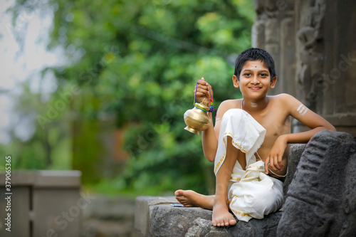 A indian priest child with holy water pot photo