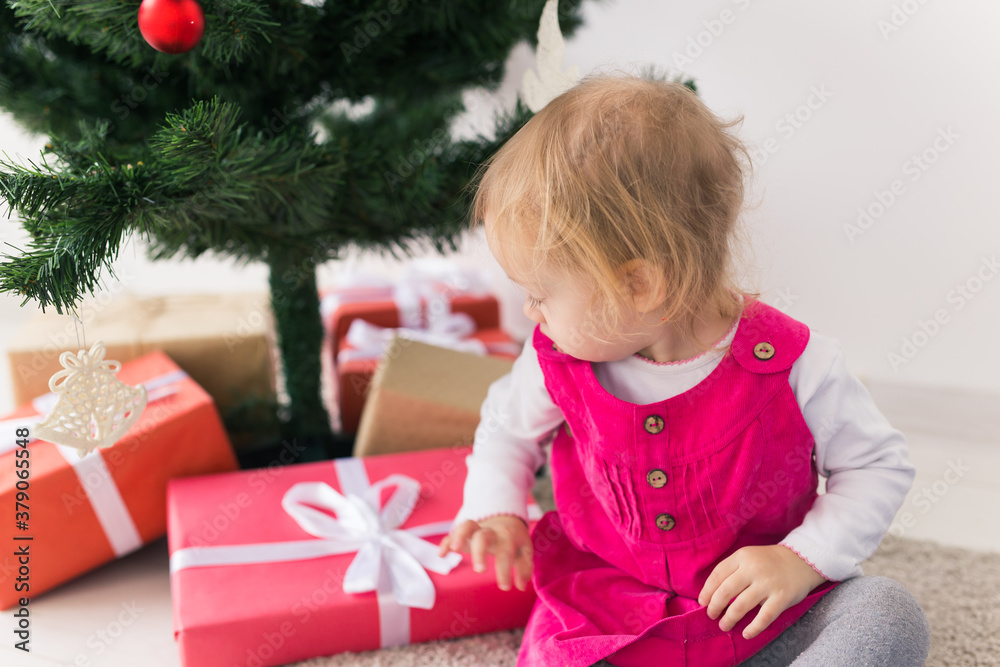 Child holding Christmas gift. Kid having fun at home. Xmas winter holiday concept Child holding Christmas gift. Kid having fun at home. Xmas winter holiday concept