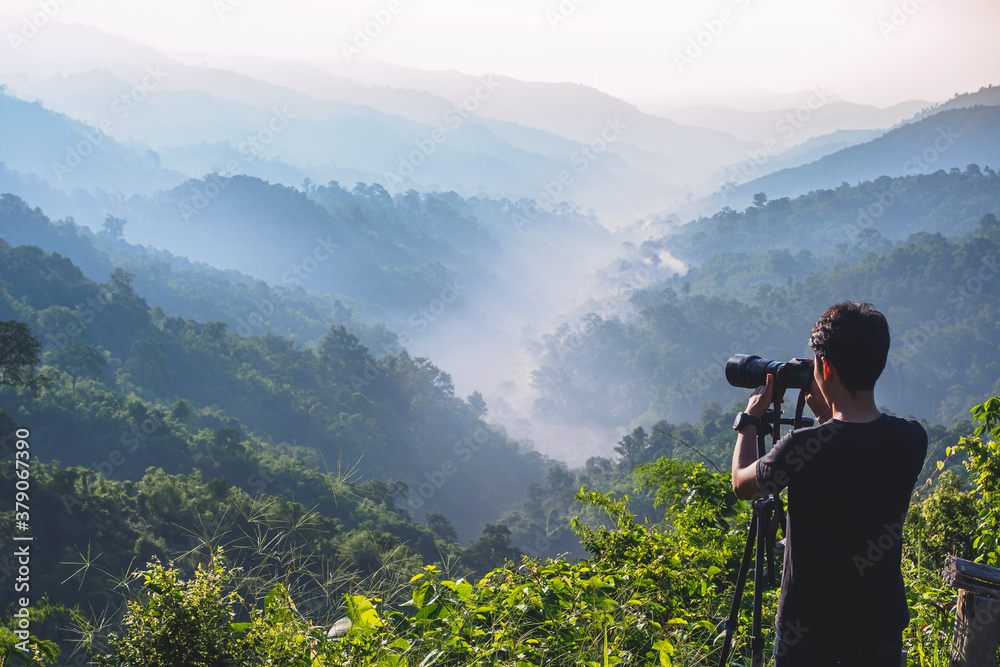 cameraman enjoying the nature view of hills and mountain are complex in the morning sunrise, at Mae Wong National park, Kamphaeng Phet, Thailand.