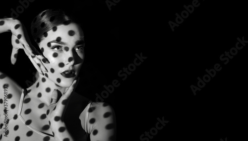 Black and white portrait of a beautiful woman with a shadow pattern on the face and body in the form of stripes.