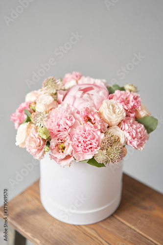 Beautiful spring bouquet in round box. Arrangement with various flowers. The concept of a flower shop. A set of photos for a site or catalogue. Work florist.