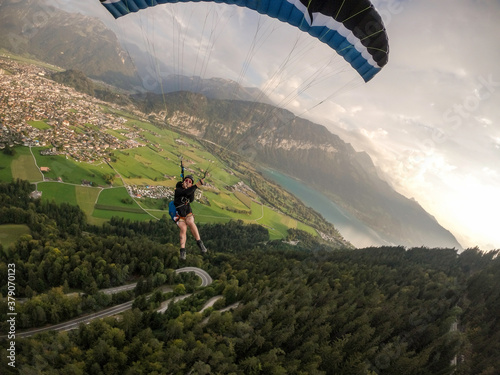 Extreme paraglider flying above Swiss Alps, Switzerland