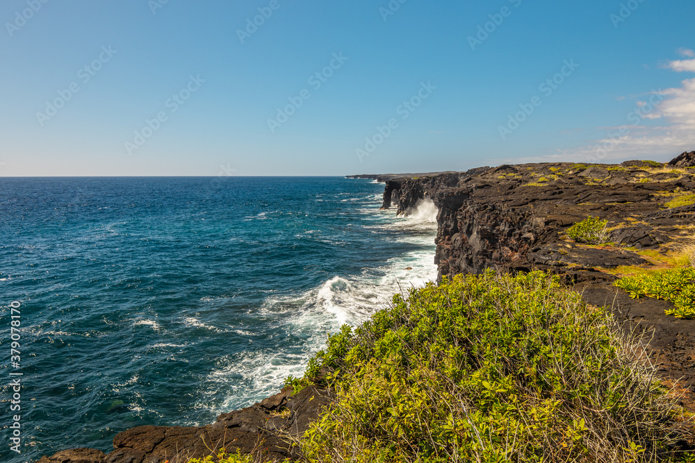 Cliffs on the seashore. Large boulder among the waves in the sea. Hawaii