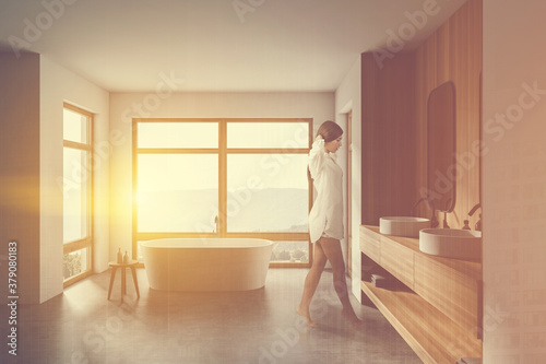 Woman walking in white and wooden bathroom