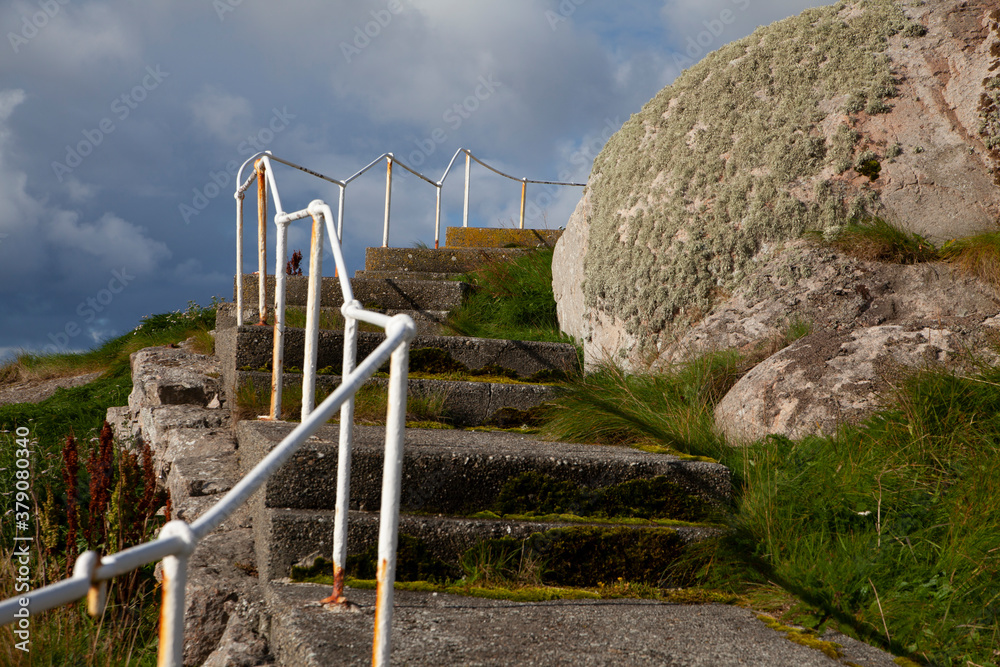 cast staircase from the seafront and up to a lighthouse located in a weather-hard fishing village on the coast of Norway