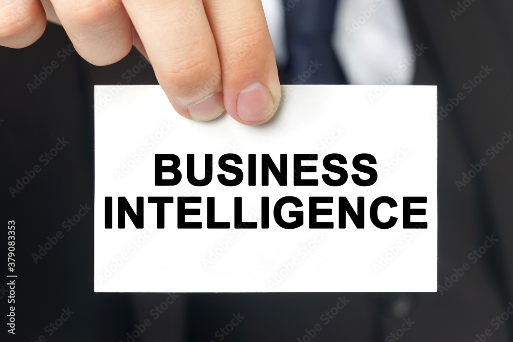 Businessman shows a card with the text - BUSINESS INTELLIGENCE Businessman shows a card with the text - BUSINESS INTELLIGENCE