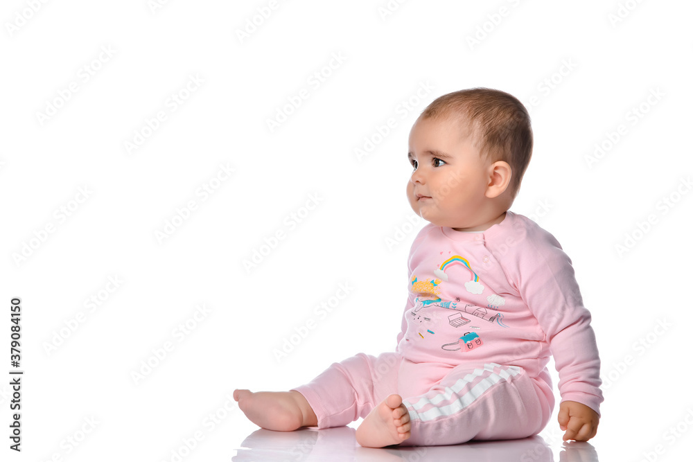 Child sits sideways looks away and smiles on a white background. Child sits sideways looks away and smiles on a white background.