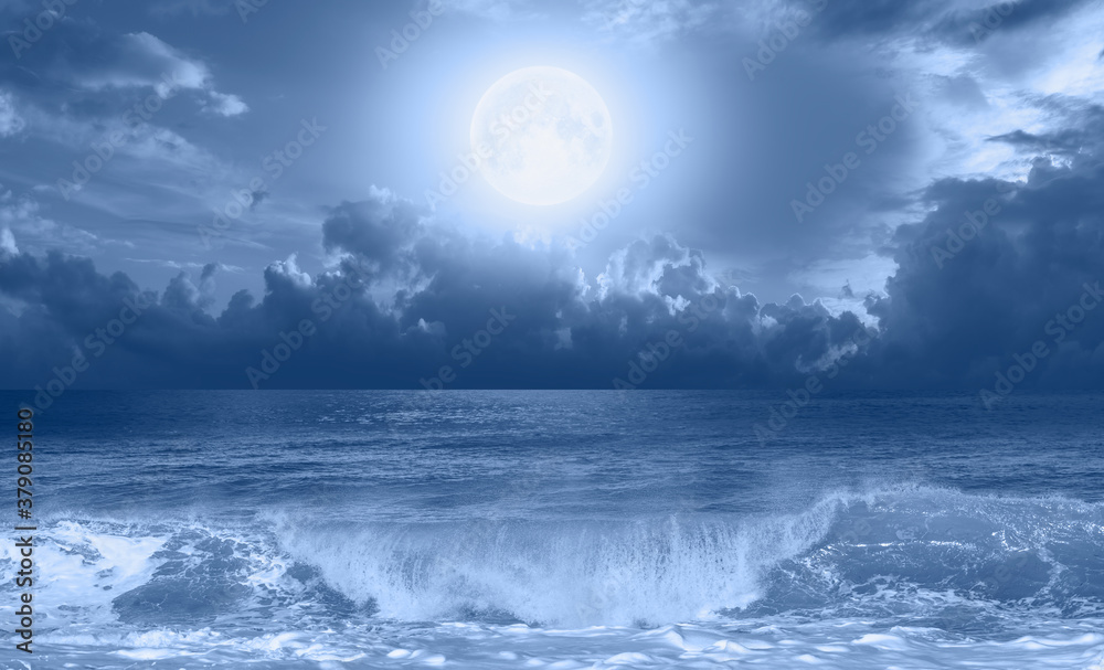 Night sky with Blue moon in the clouds on the fore ground calm blue sea 