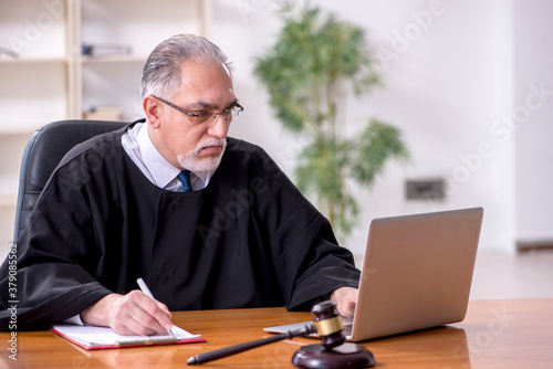 Old male judge working in courthouse