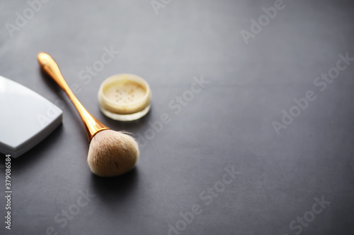 Powder and makeup brush. Brown powder on the background. Makeup products. Style concept.