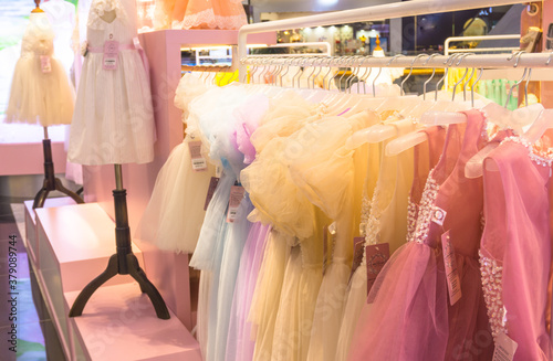 Dresses are hung on shelves in clothing stores. Lovely dresses for girls on birthdays, celebration, holiday, competitions,..