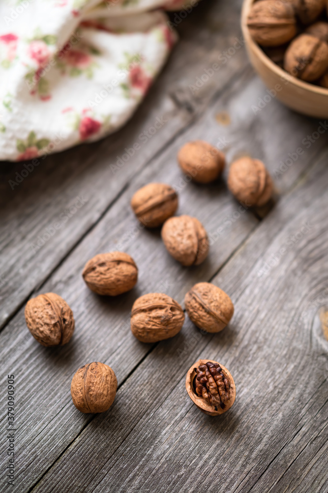 Whole walnuts in a bowl and on rustic old wooden table. Healthy organic food, BIO viands, natural background. Copy space for your advertising text message Whole walnuts in a bowl and on rustic old wooden table. Healthy organic food, BIO viands, natural background. Copy space for your advertising text message