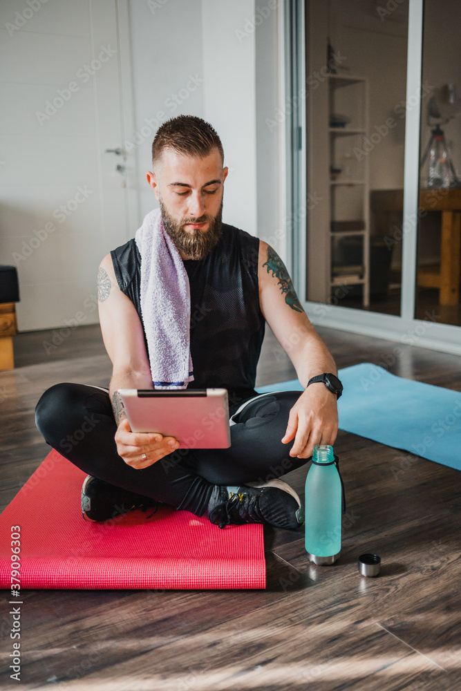Handsome bearded guy looking at his tablet Handsome bearded guy looking at his tablet