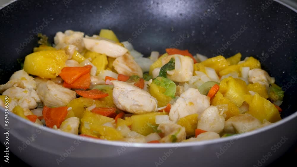 Fry vegetable stew in pan on hot stove. Healthy eating food. Chopped carrots, bell peppers, pieces of chicken white meat Fry vegetable stew in pan on hot stove. Healthy eating food. Chopped carrots, bell peppers, pieces of chicken white meat