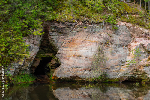 Beautiful sandstone cliffs in South Estonia, Taevaskoja (Taevaskoda) nature trail, Maiden's cave, Ahja river. Engraved writings and name on the cliff by tourists.