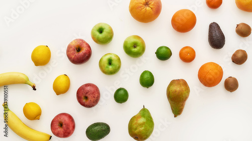 Top view of rainbow composition of various colorful fresh fruits isolated over white background