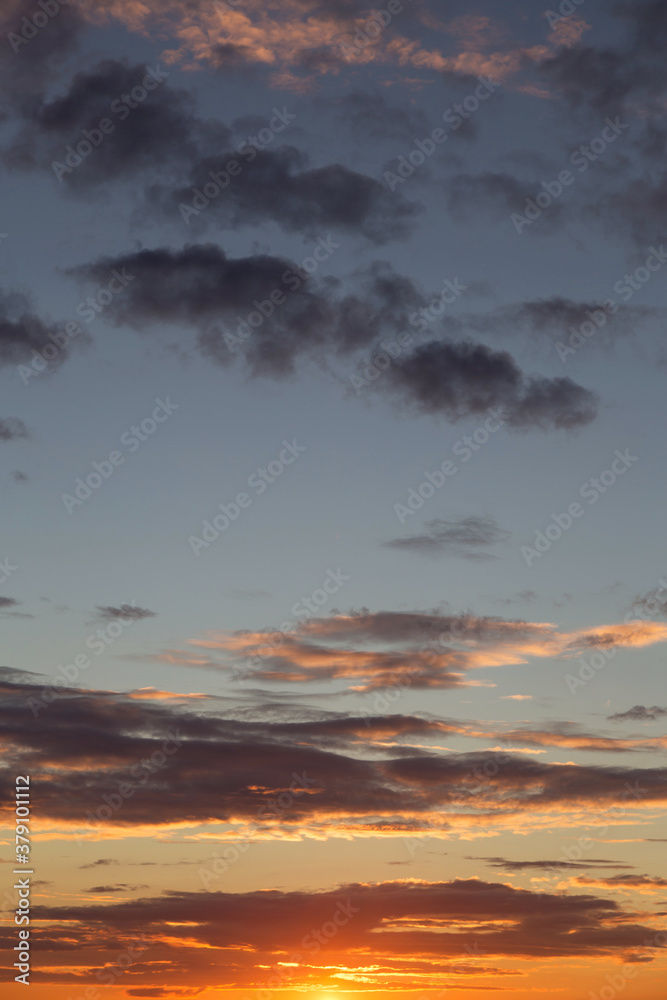 Beautiful sunrise, sunset orange yellow blue sky with clouds and sunlight background texture