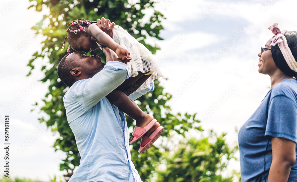 Portrait of enjoy happy love black family african american father and mother with little african girl child smiling and having fun moments good time in summer park at home