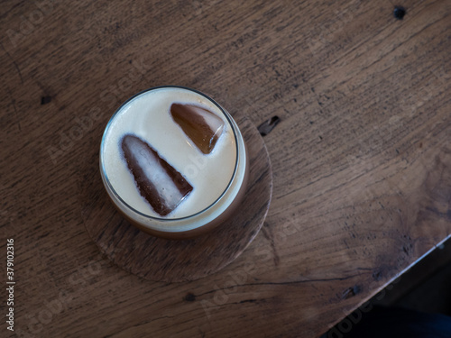 Top view of ice coffee in glass on wood table