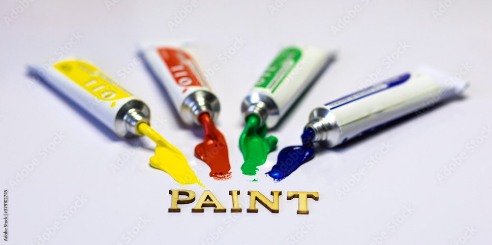 Schriftzug PAINT mit Farbtuben gelb rot grün blau ausgequetscht Schriftzug PAINT mit Farbtuben gelb rot grün blau ausgequetscht
