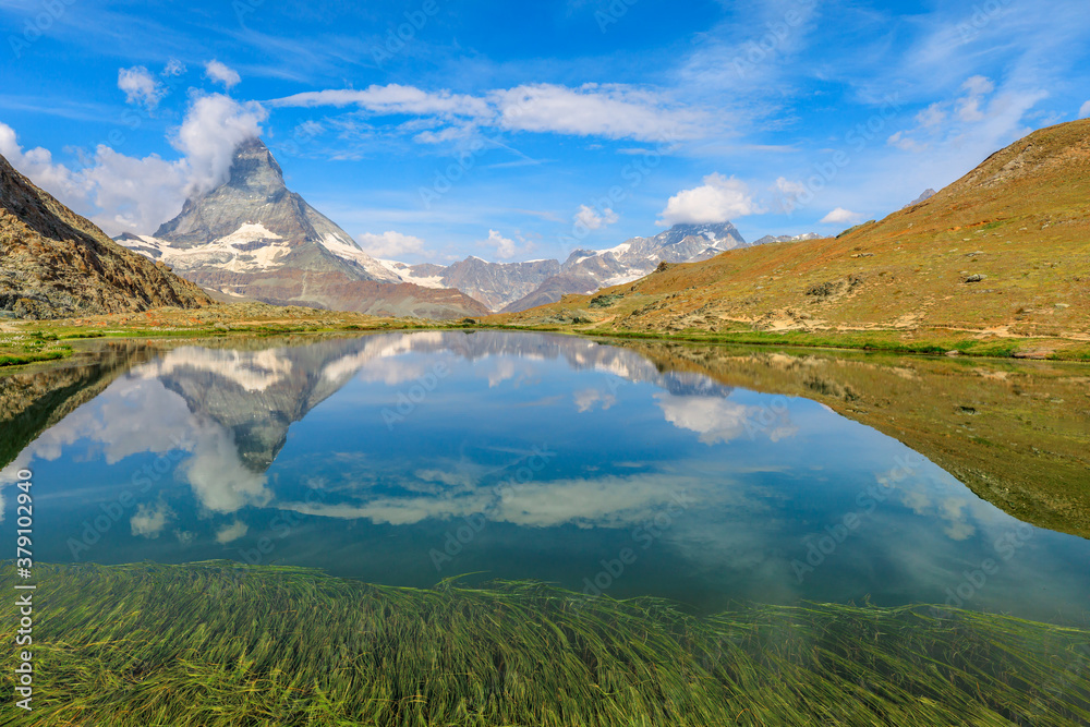 Reflection of Mount Matterhorn on Riffelsee Lake in Zermatt, mountain resort in Swiss Alps, Canton of Valais, Switzerland. Riffelsee is located on Riffelseeweg trail on Gornergrat Bahn cog railway.