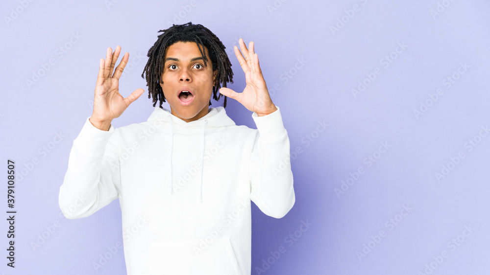 Young african american rasta man celebrating a victory or success, he is surprised and shocked. Young african american rasta man celebrating a victory or success, he is surprised and shocked.