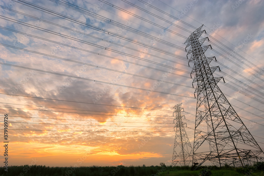 Pylon and power lines shot against sunset