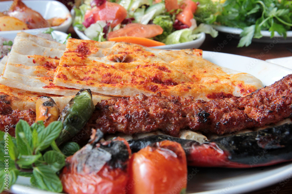 delicious Adana kebabs and salads on the plate