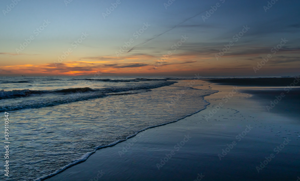 Zachód słońca na plaży w Egmond aan Zee, Holandia Północna.