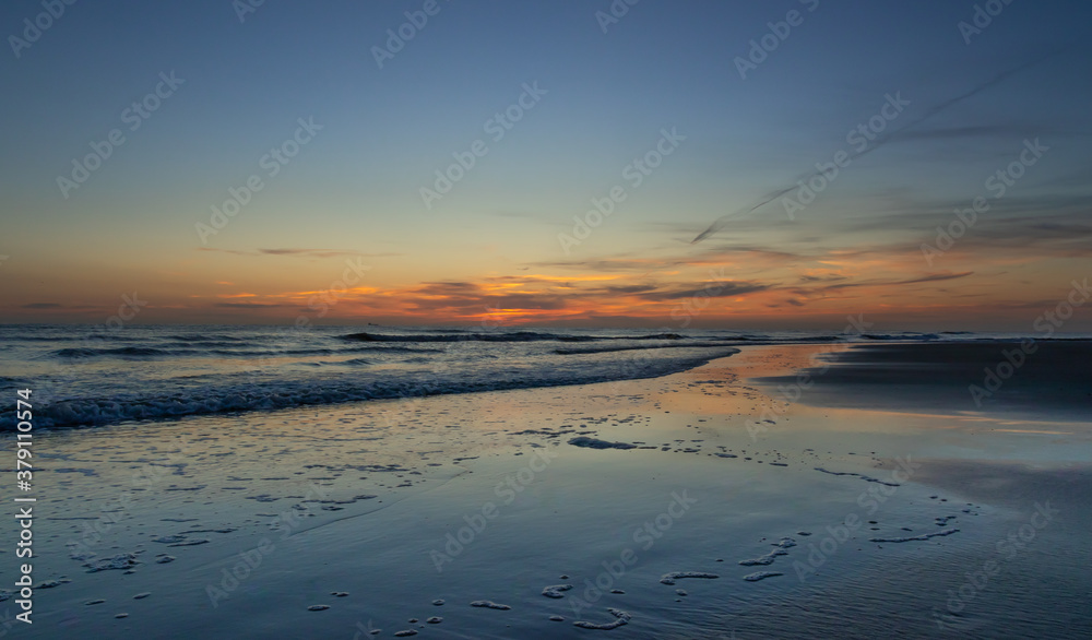Zachód słońca na plaży w Egmond aan Zee, Holandia Północna.